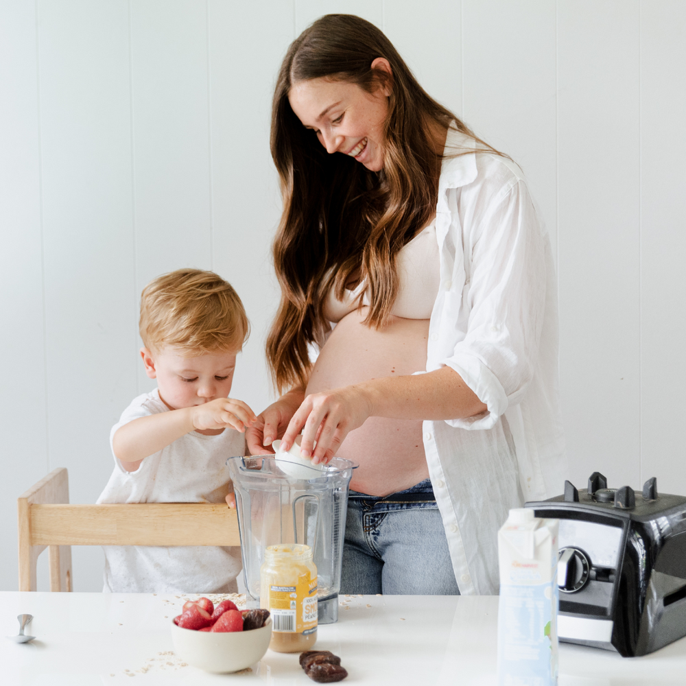 naturopath and co founder of mother's mylk with her son and pregnant preparing a meal during pregnancy and for toddlers
