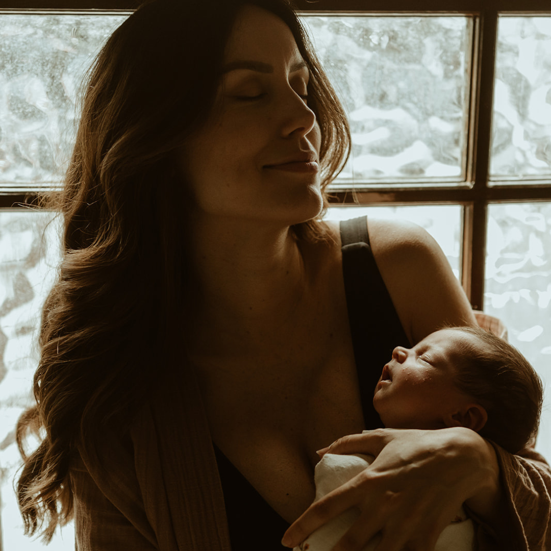 owner of bare mum amelie holds baby girl in her postpartum glow