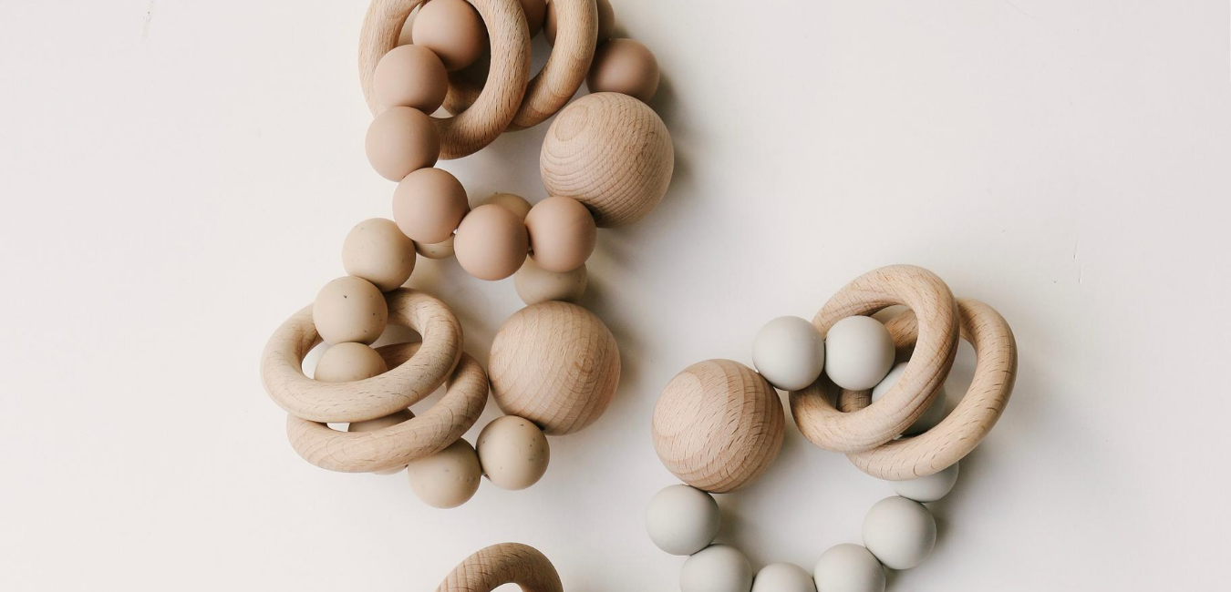 A set of wooden teethers hanging on a wall.