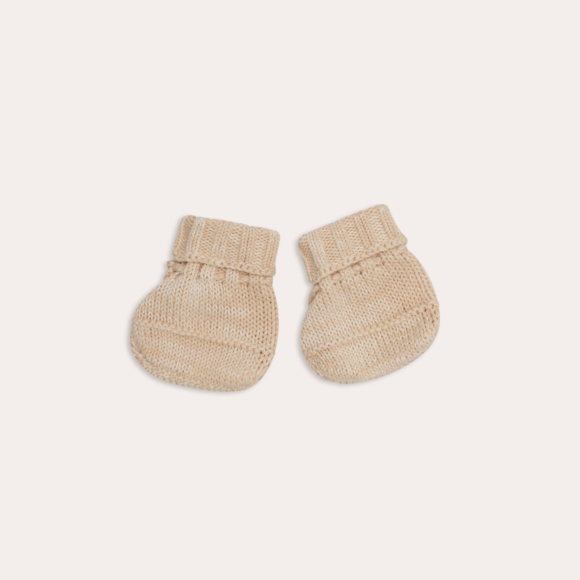 A pair of Illoura the Label beige baby socks on a white background.