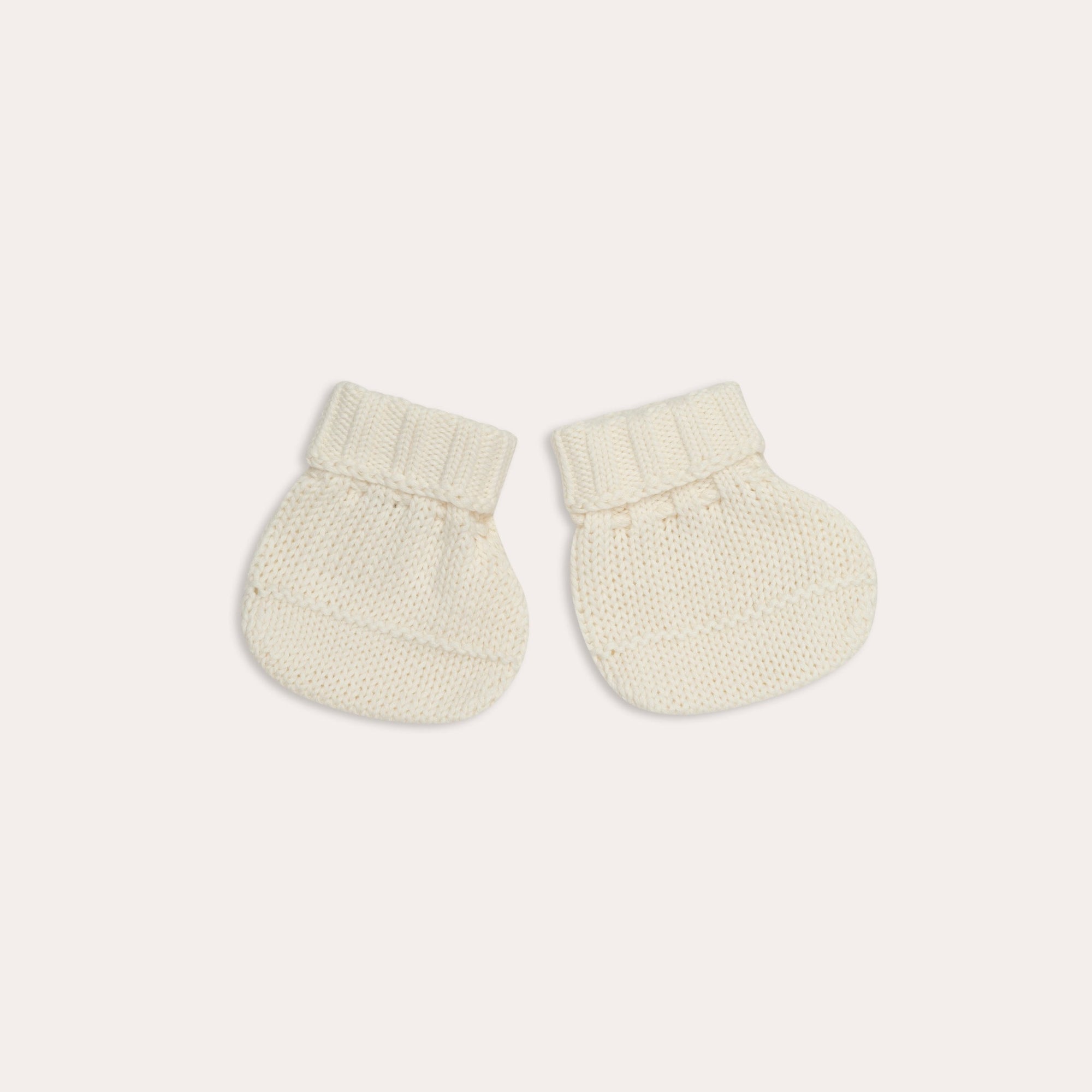 A pair of Illoura knitted alba booties in vanilla color on a white background. (Brand: Illoura the Label)