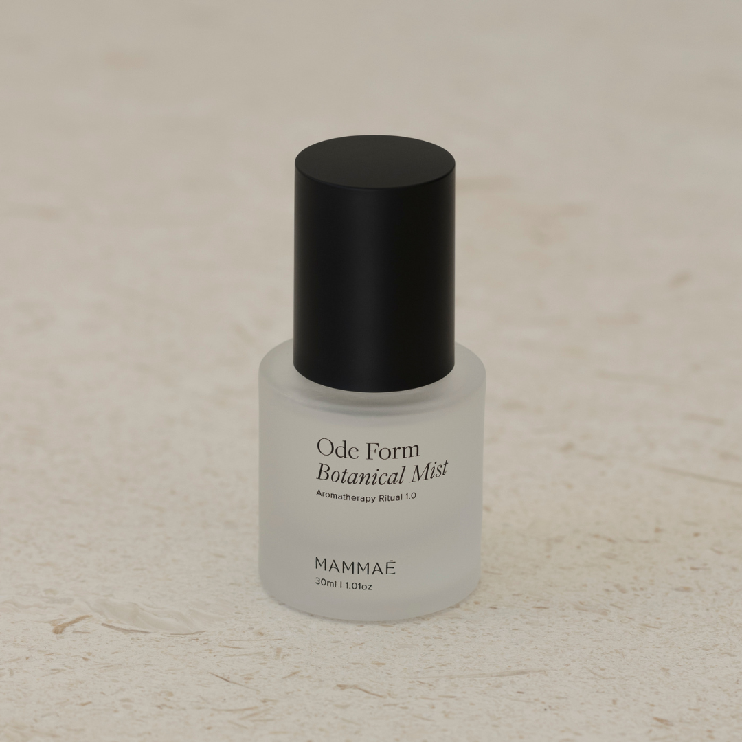 A bottle of EXCLUSIVE mini ode form botanical mist by Mammae on a white surface, perfect for botanical alchemy.