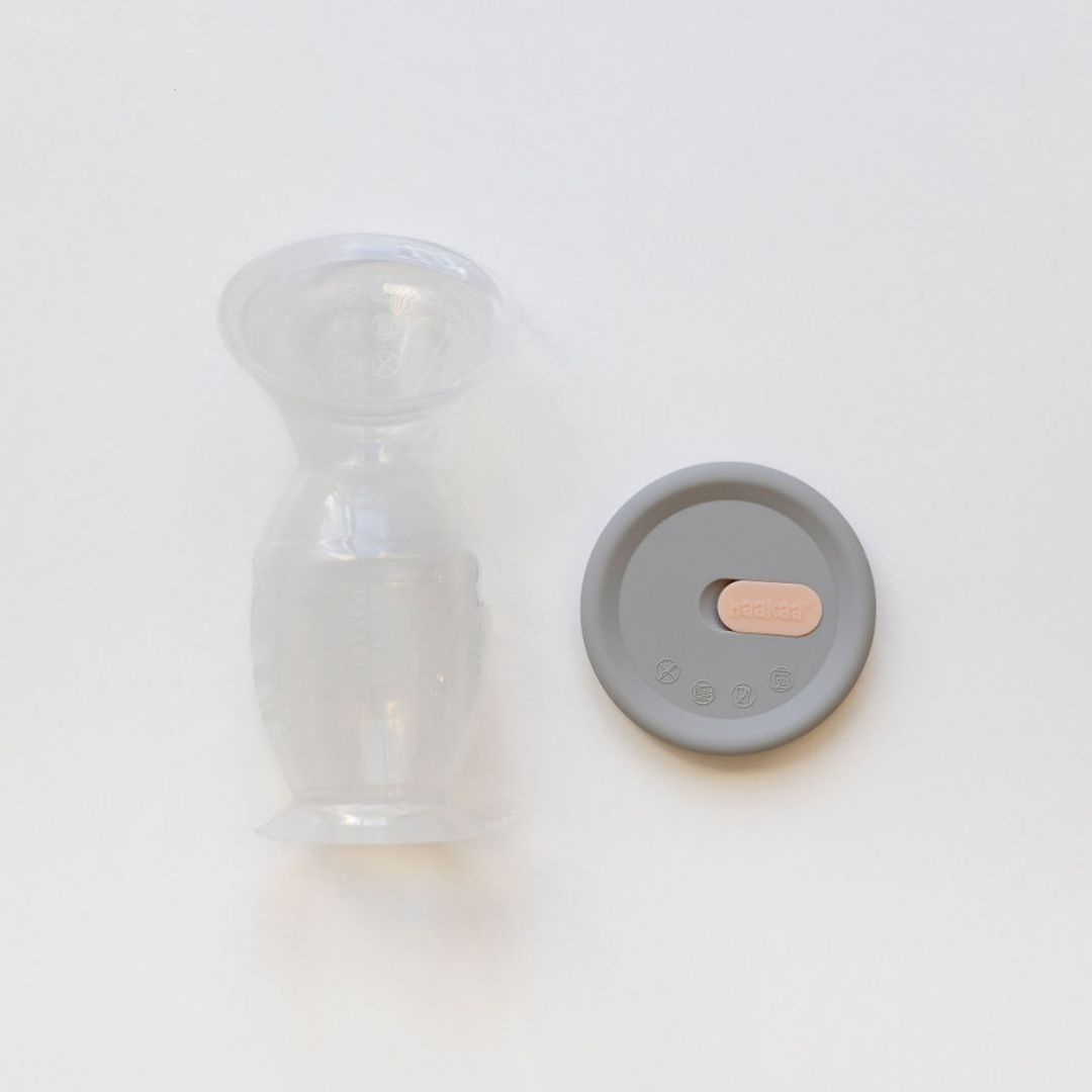 A Haakaa Silicone Breast Pump & Silicone Cap Gen 2 with a lid next to it.