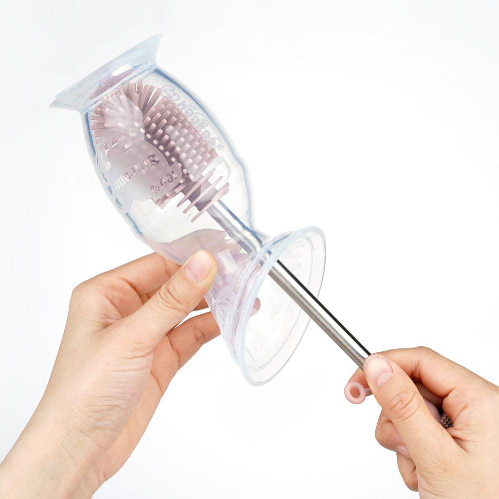 A person using the Haakaa Silicone Cleaning Brush Kit by Haakaa to clean their teeth.
