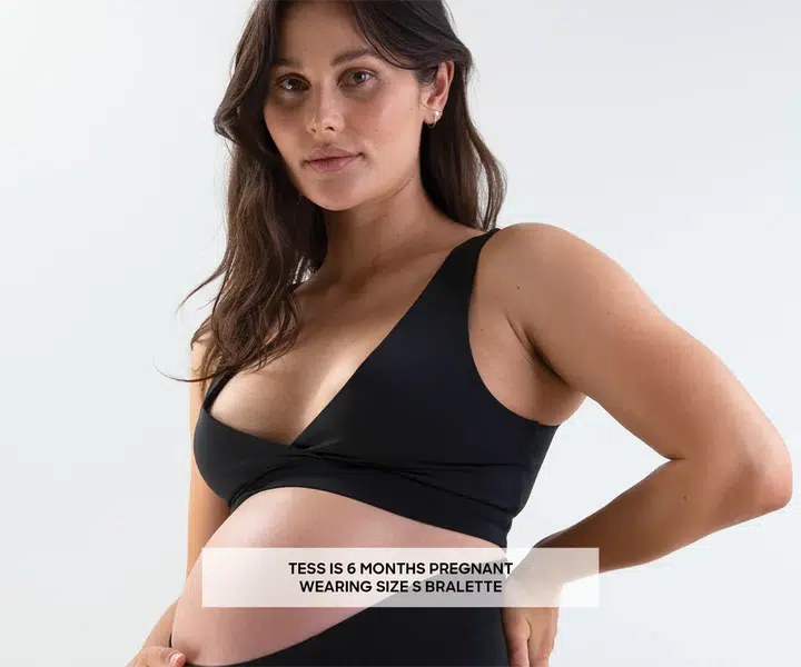 A breastfeeding mother is modeling a Postpartum Bralette by Bare Mum.