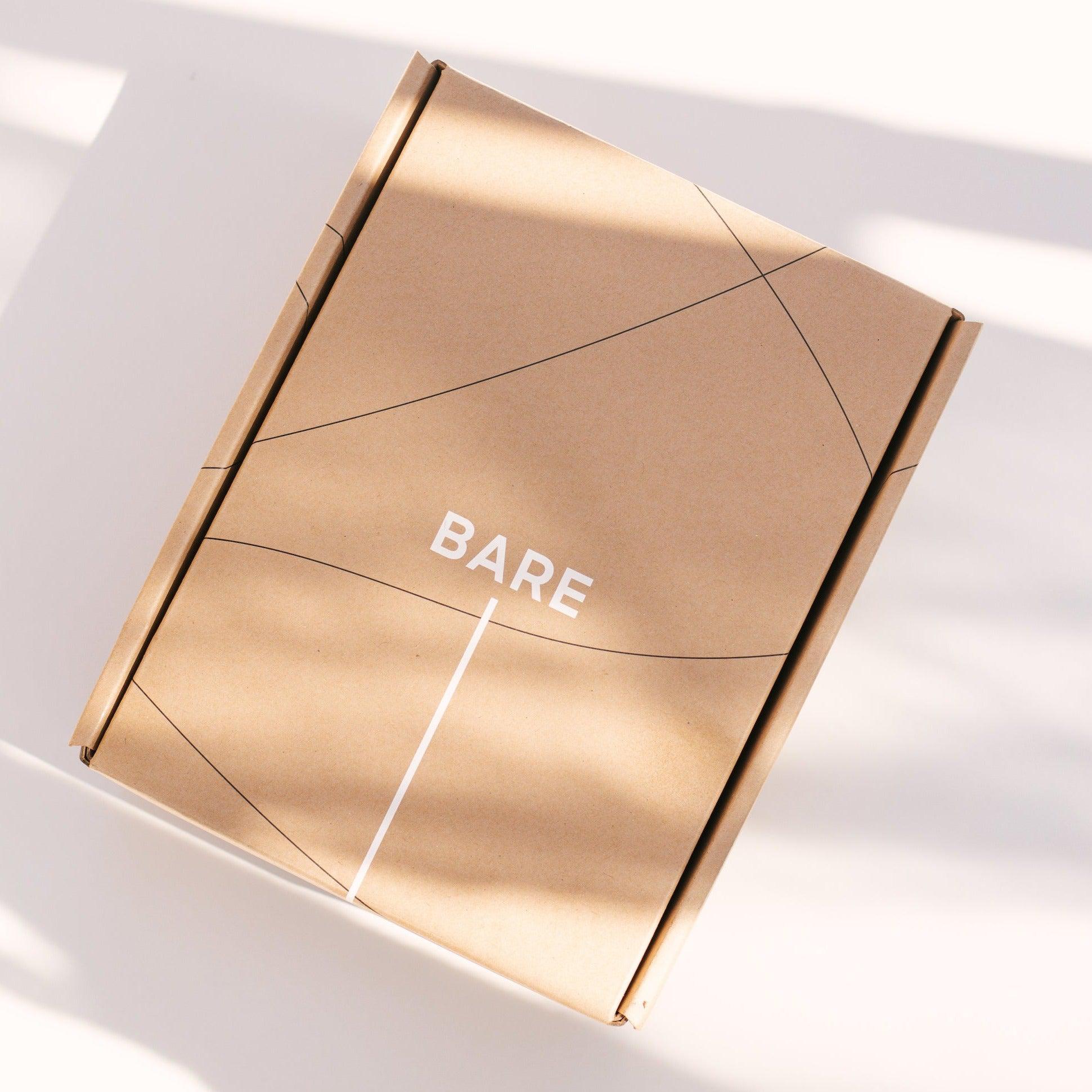 A box for postpartum recovery, "The Bare Essentials Kit," sits on a white surface.