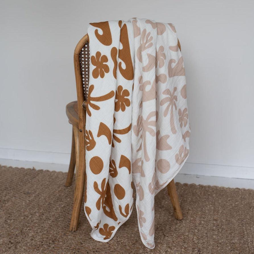 A white and brown Bundl. coastal blanket sitting on a chair.