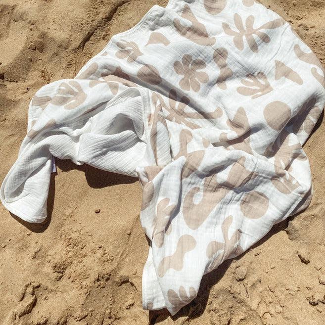 A Bundl. coastal blanket laying on the coastal sand.