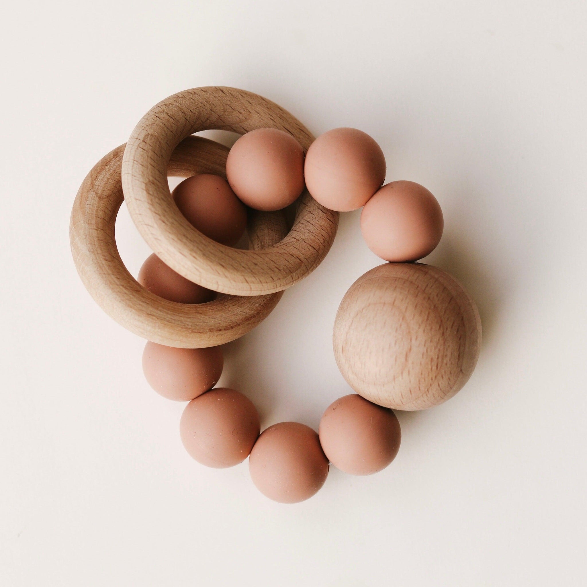 Two untreated wood rings move freely around the circle of 20mm BPA free silicone beads creating a soft rattle when baby shakes. All finished off with massive 35mm untreated beech wood bead.