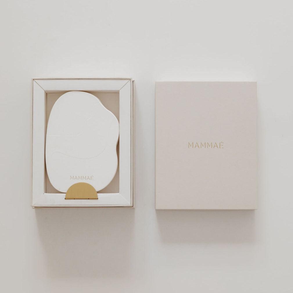 A postpartum bosom reflections box with a gold sticker on it from Mammae for breast care.