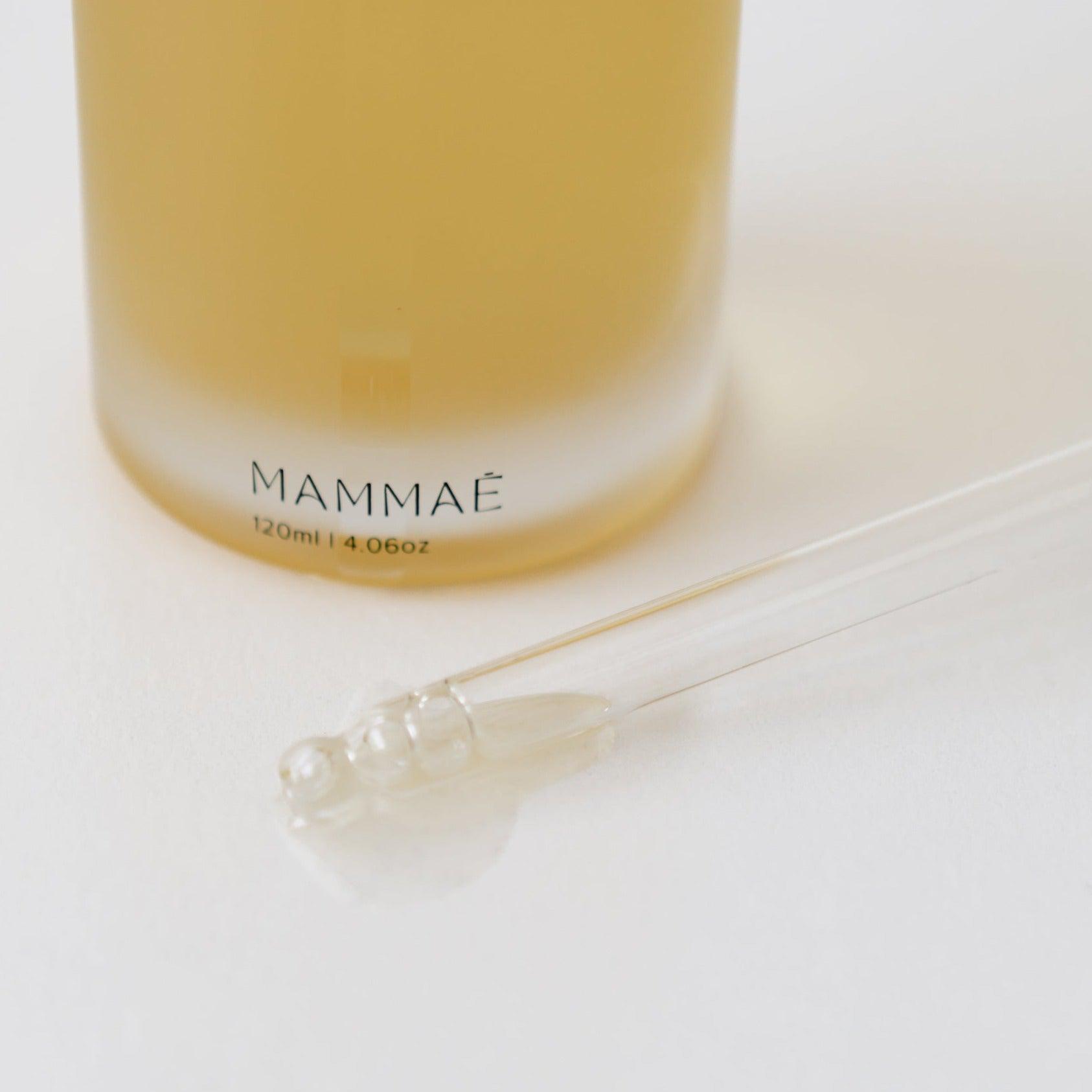A bottle of Mammae bosom ritual elixir for breast care including breast massage, mastitis support with a glass dropper applique.