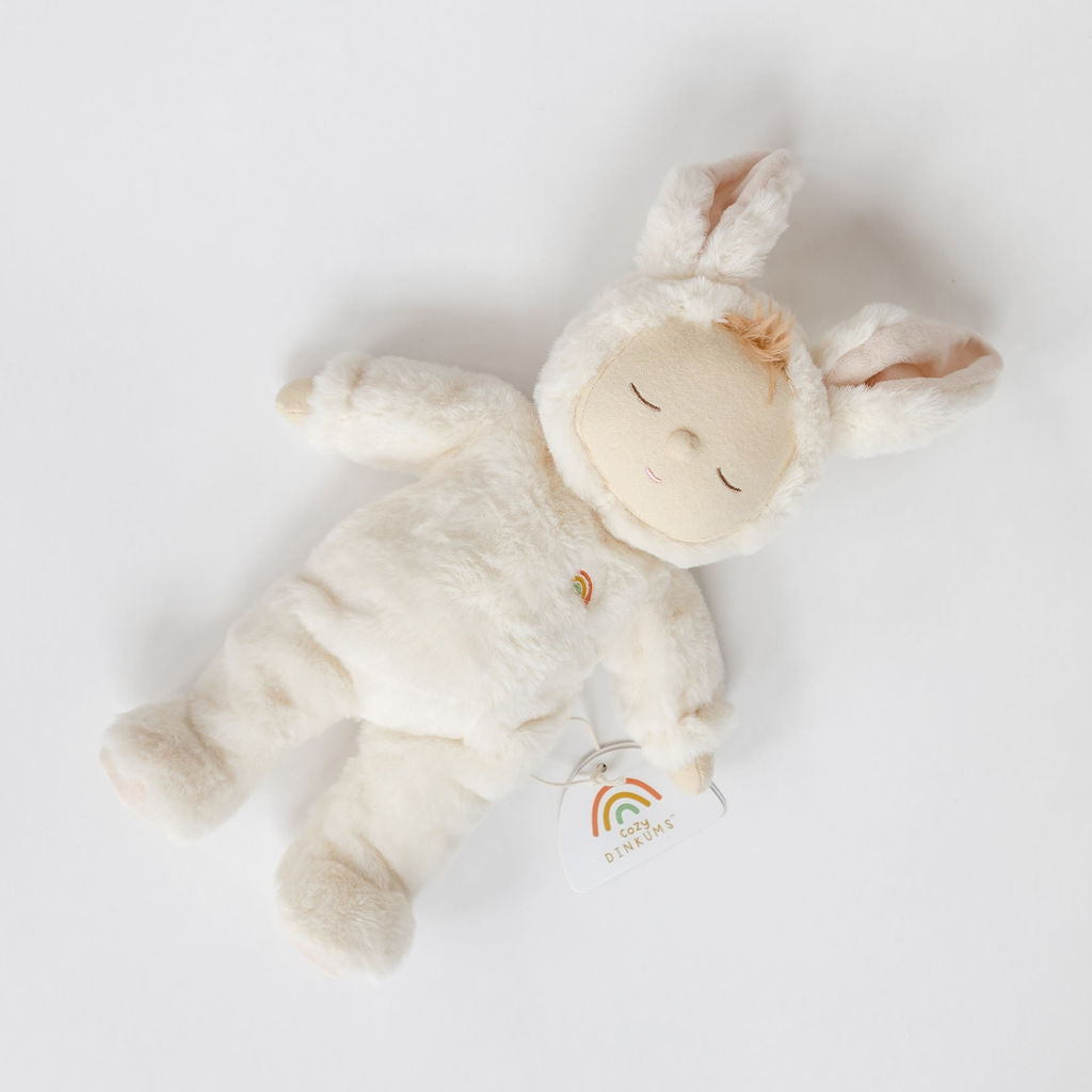 A white Cozy Dinkums bunny moppet stuffed animal lying on a white surface by Olli Ella.