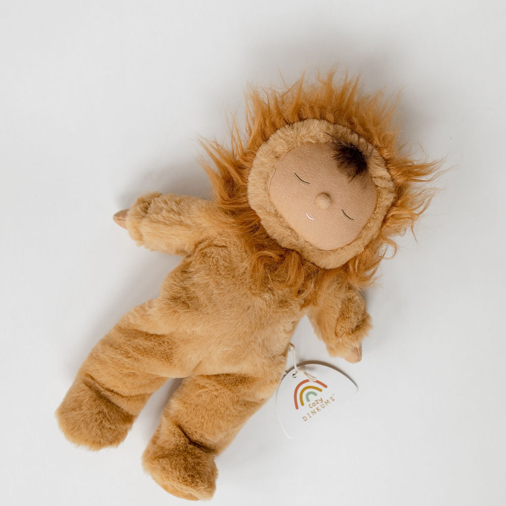 A Cozy Dinkums lion pip lying on a white surface. Brand Name: Olli Ella