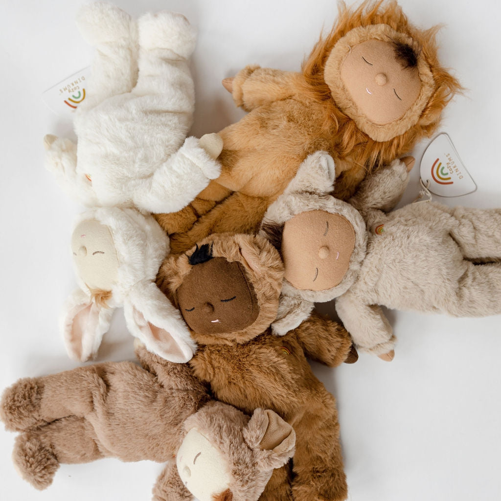 A group of Olli Ella cozy dinkums | teddy mini stuffed animals laying on a white surface.