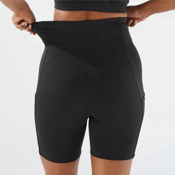 A person demonstrating the stretchability of Bare Mum Postpartum Recovery Shorts by pulling at the waistband.