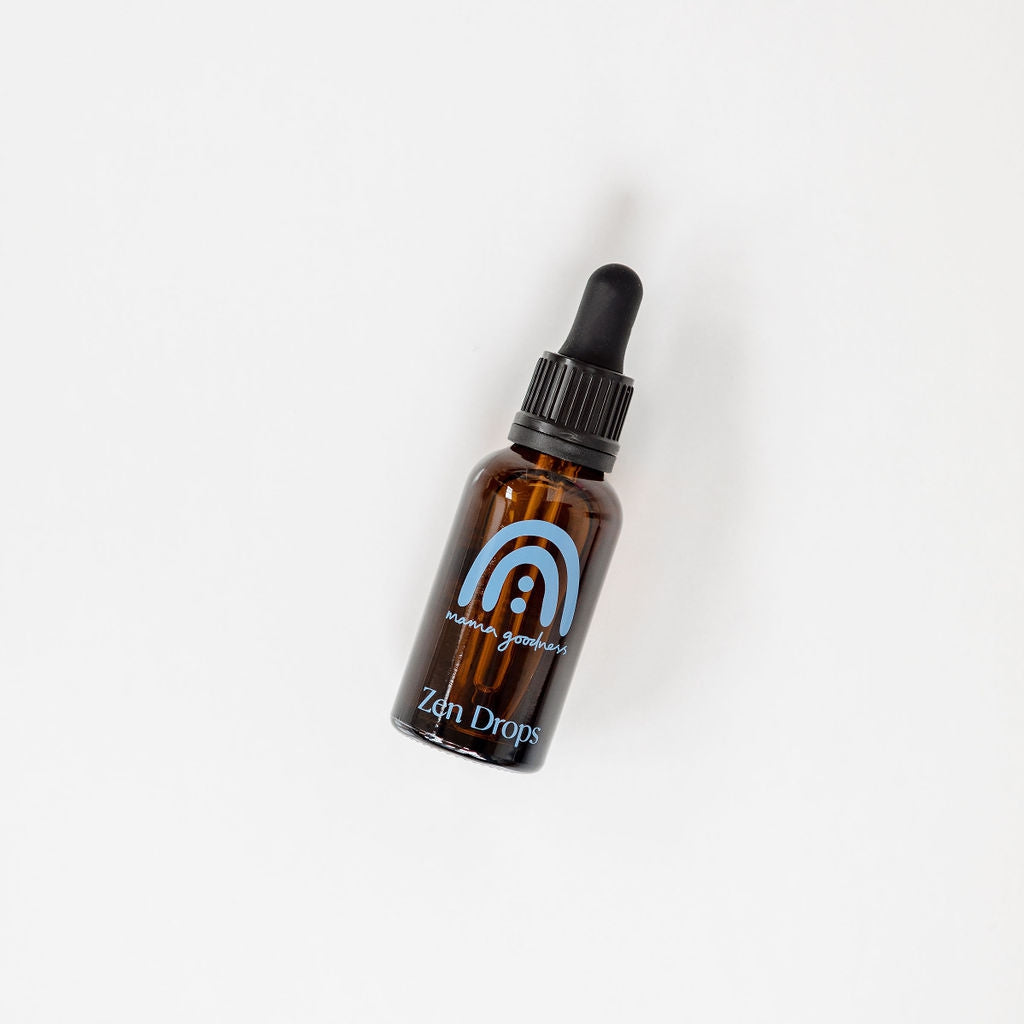 A small bottle of Mama Goodness zen drops on a white surface.