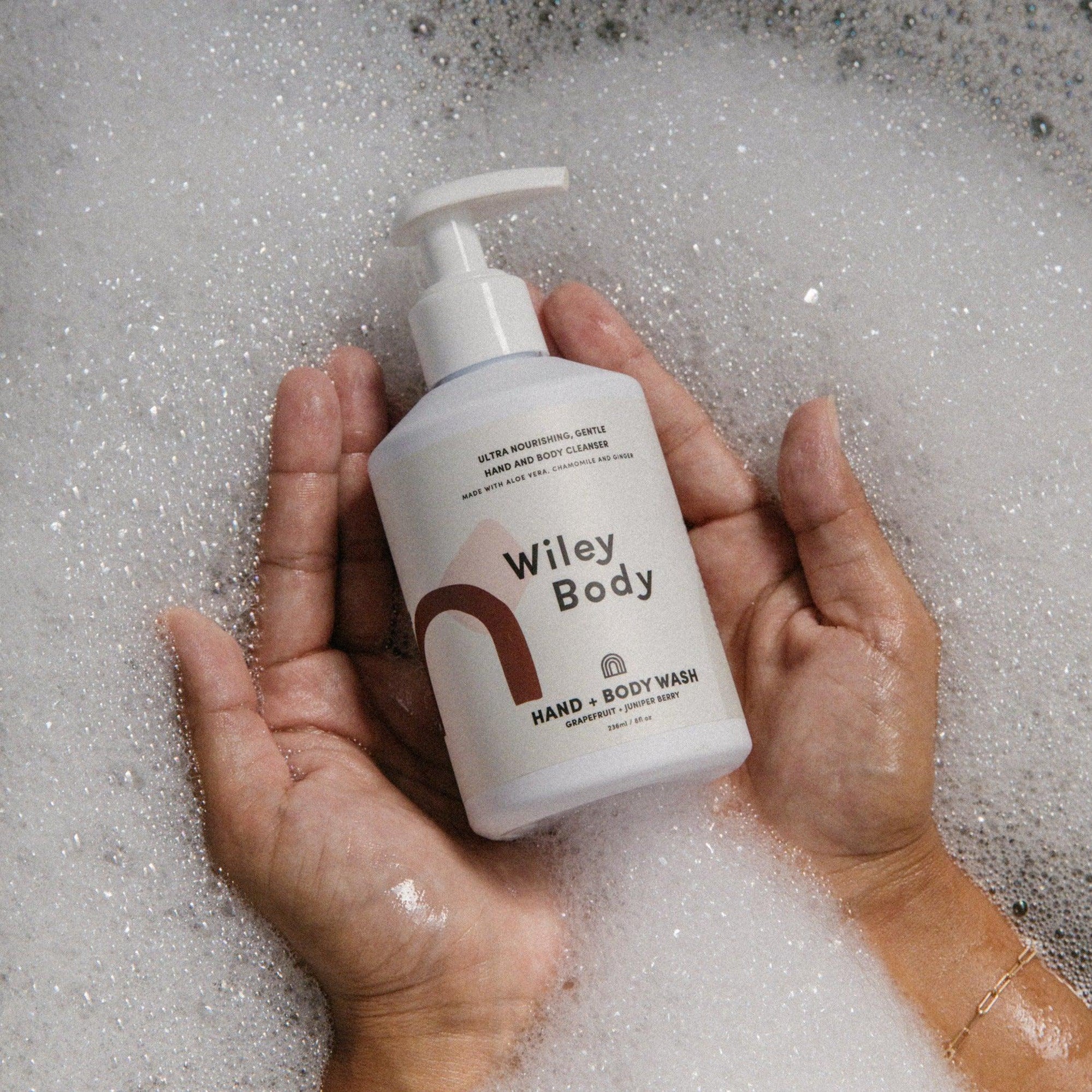 A person holding a bottle of Wiley Body hand & body wash.
