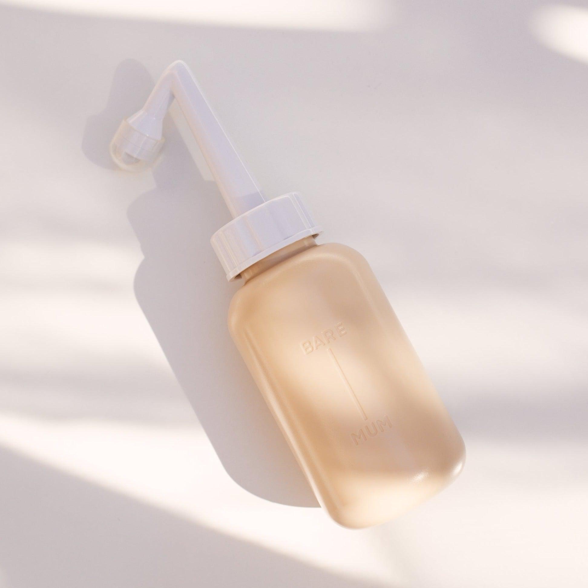 A Bare Mum Perineal Wash Bottle designed for post-birth recovery sitting on a white surface.