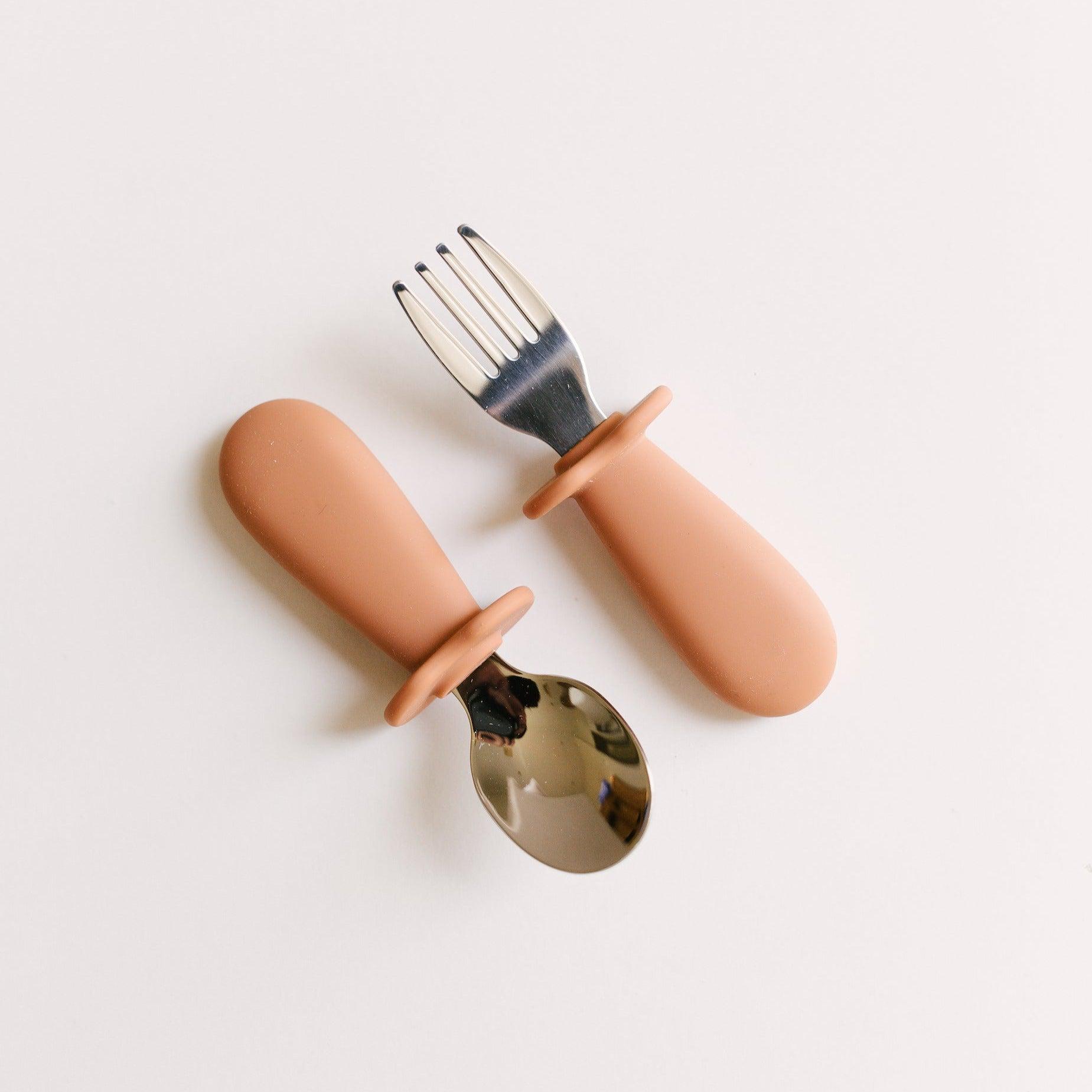 A Rommer toddler cutlery set in cinnamon, designed to encourage independence during mealtime, perfect for curious little hands.