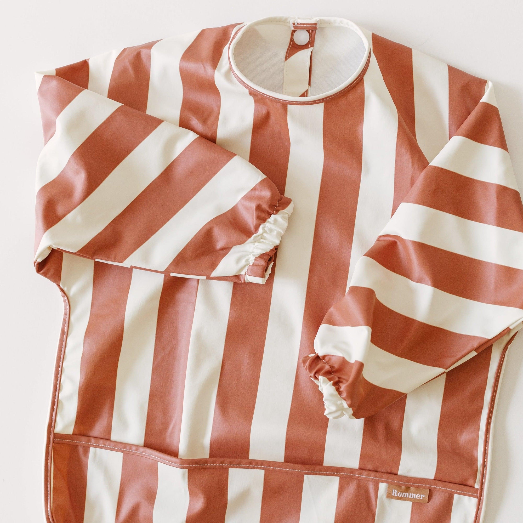 A red and white striped Rommer Smock Bib on a white background.