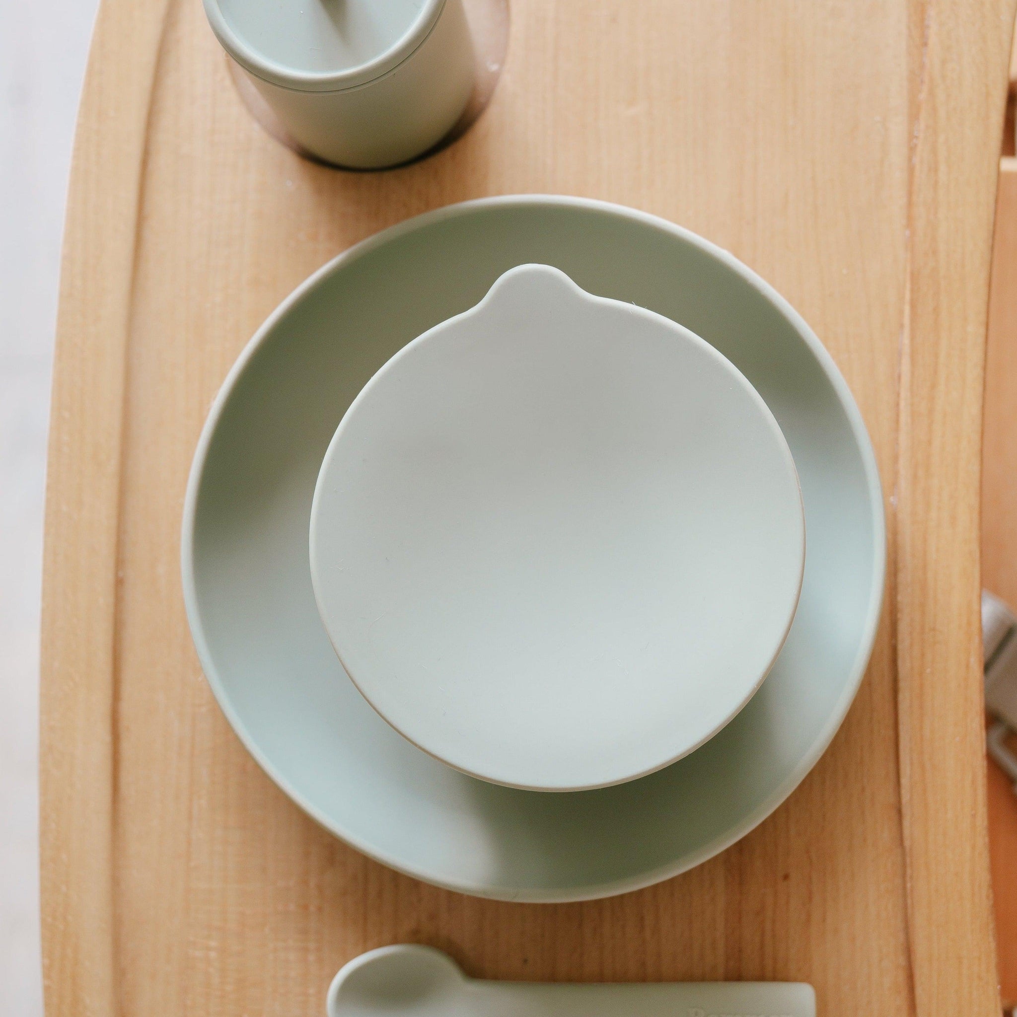 A Rommer dinner set of plates and utensils on a wooden table.