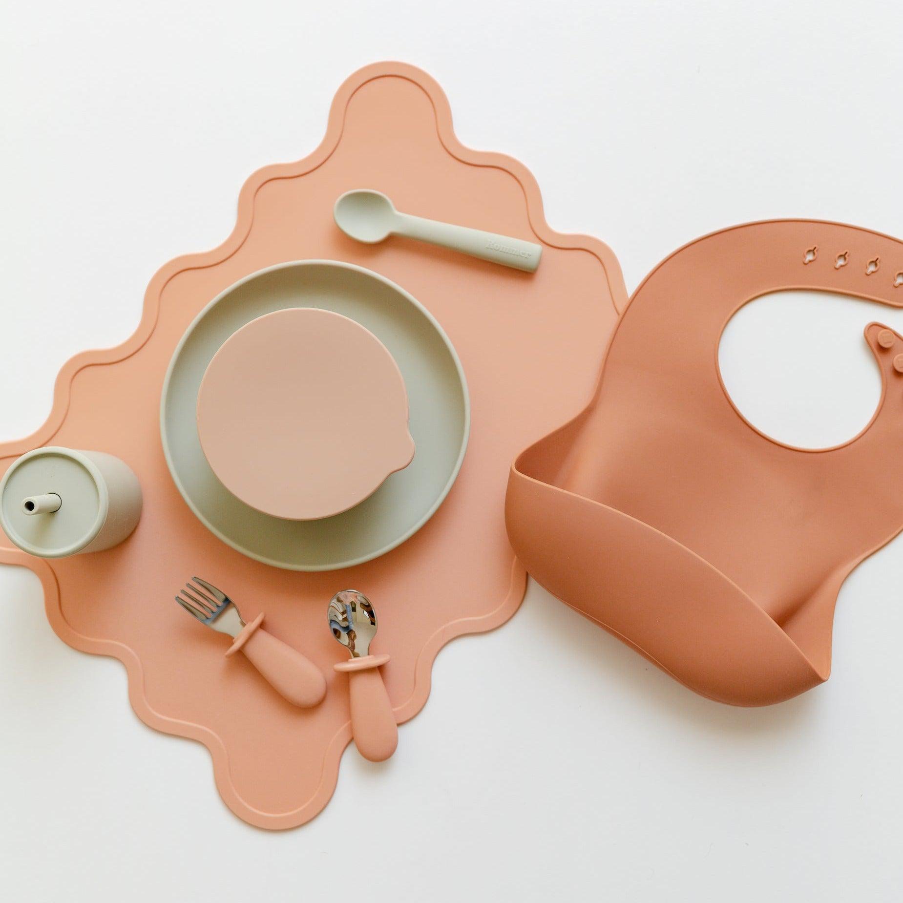 A set of Rommer Wiggly Placemat | melon plates, bowls and utensils on a table.
