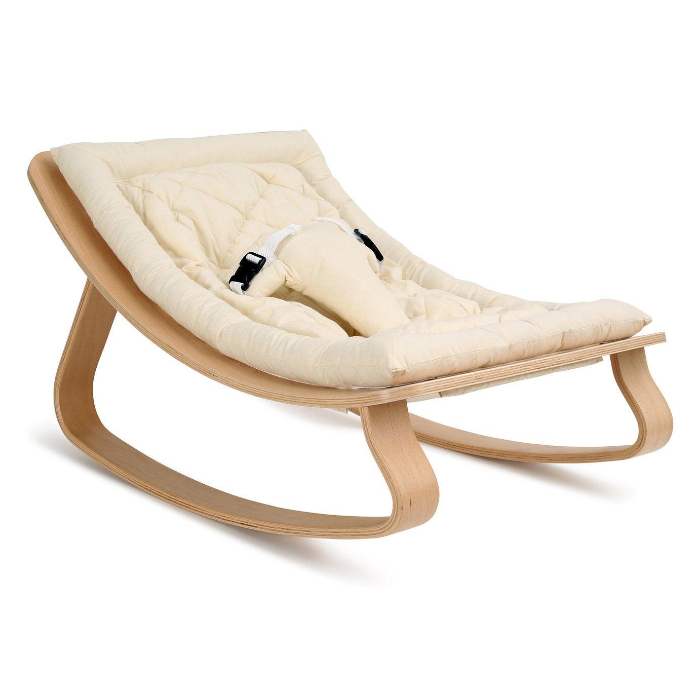 A wooden baby rocker by Charlie Crane featuring an organic white cushion.
