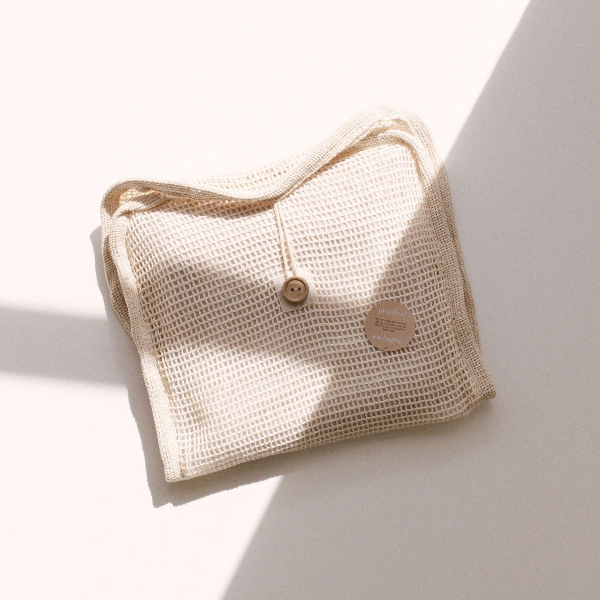 A beige bag by Chekoh sitting on a white surface.