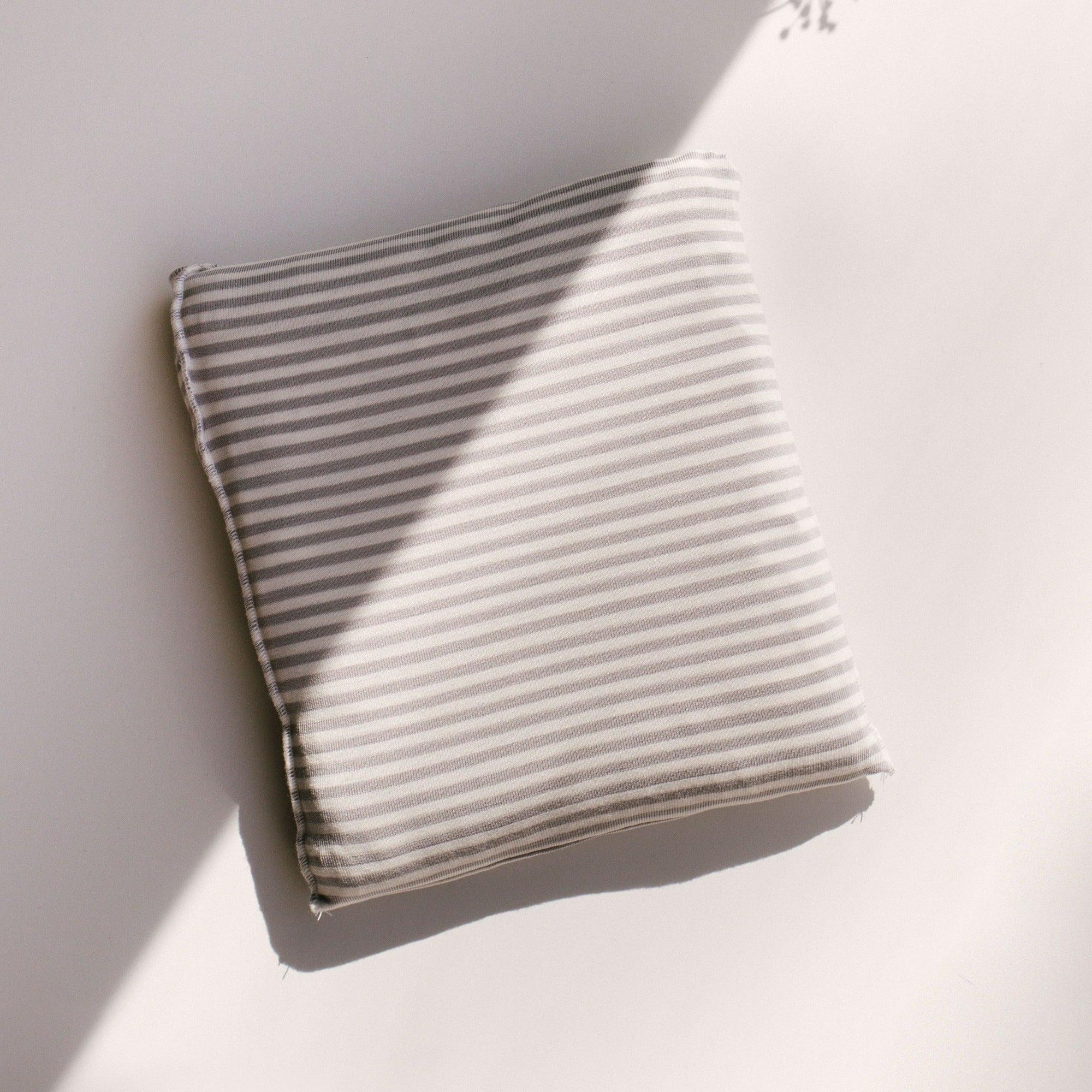 A Grey Stripe Wrap by Chekoh on a white surface.