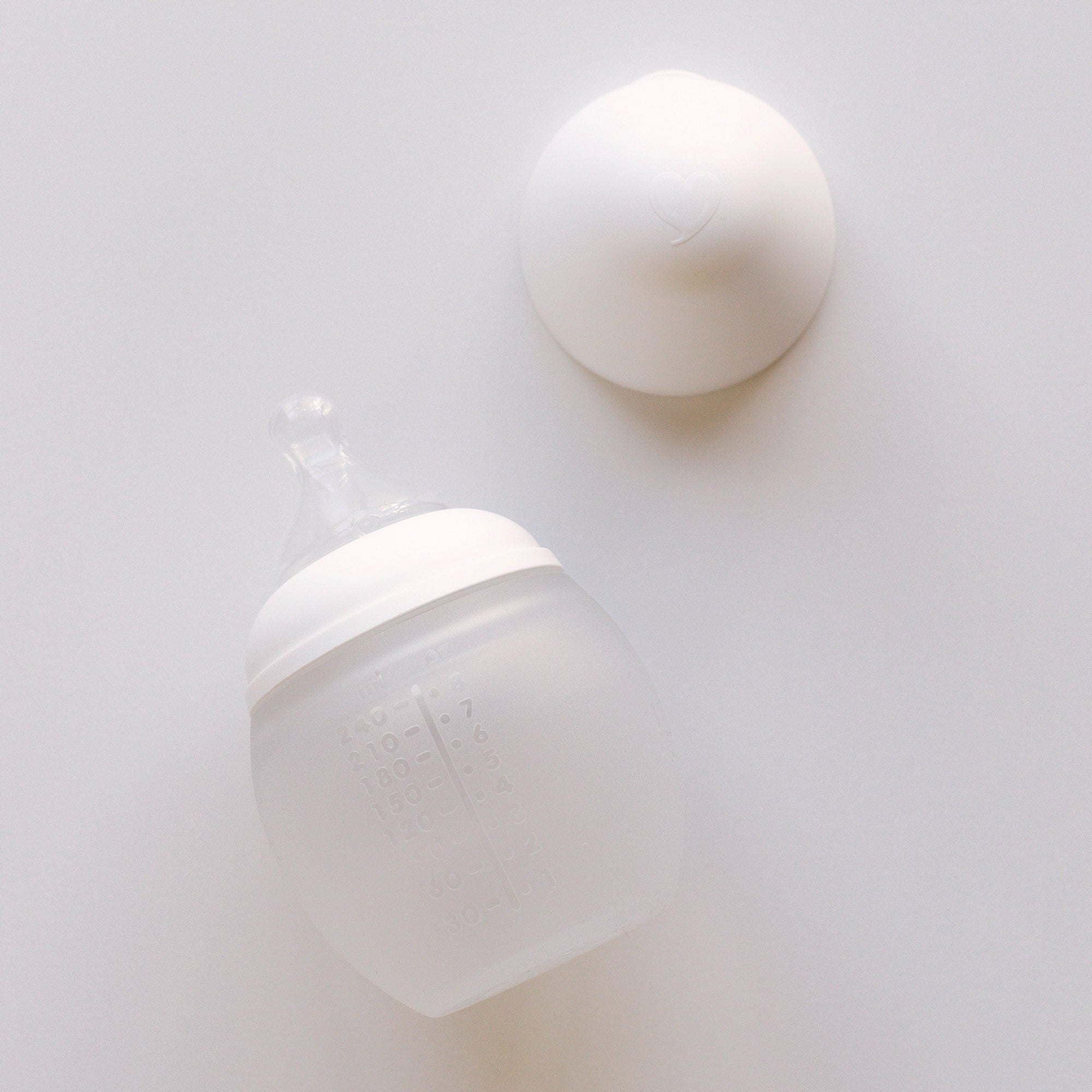 A milk BibRond bottle by Elhée France laying on a white surface.