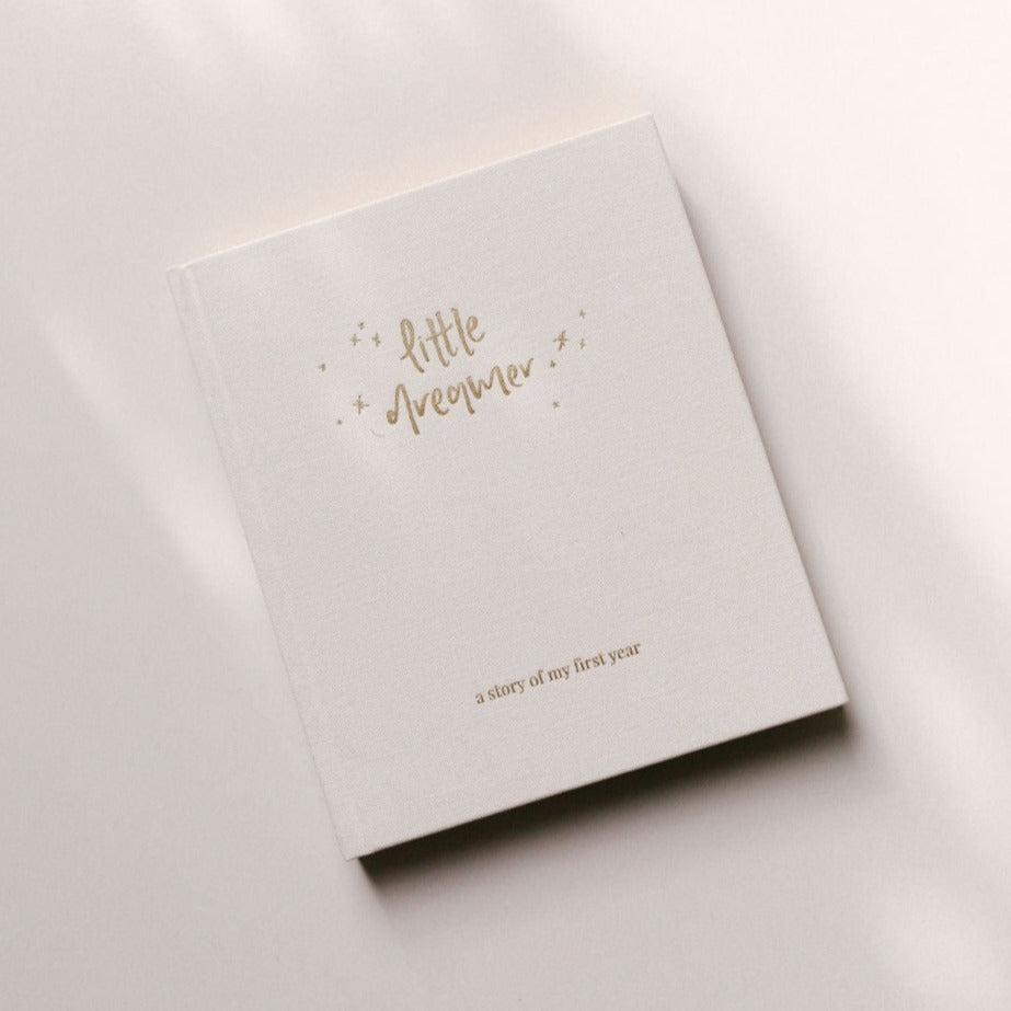 An Emma Kate Co. little dreamer baby journal in the shade cloud on a white surface.