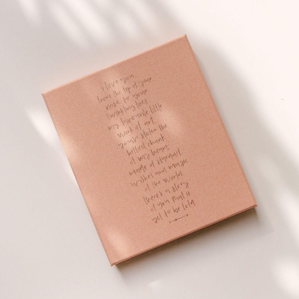 The back of the Emma Kate Co. Little Dreamer Baby Journal in petal featuring a quote in gold lettering.