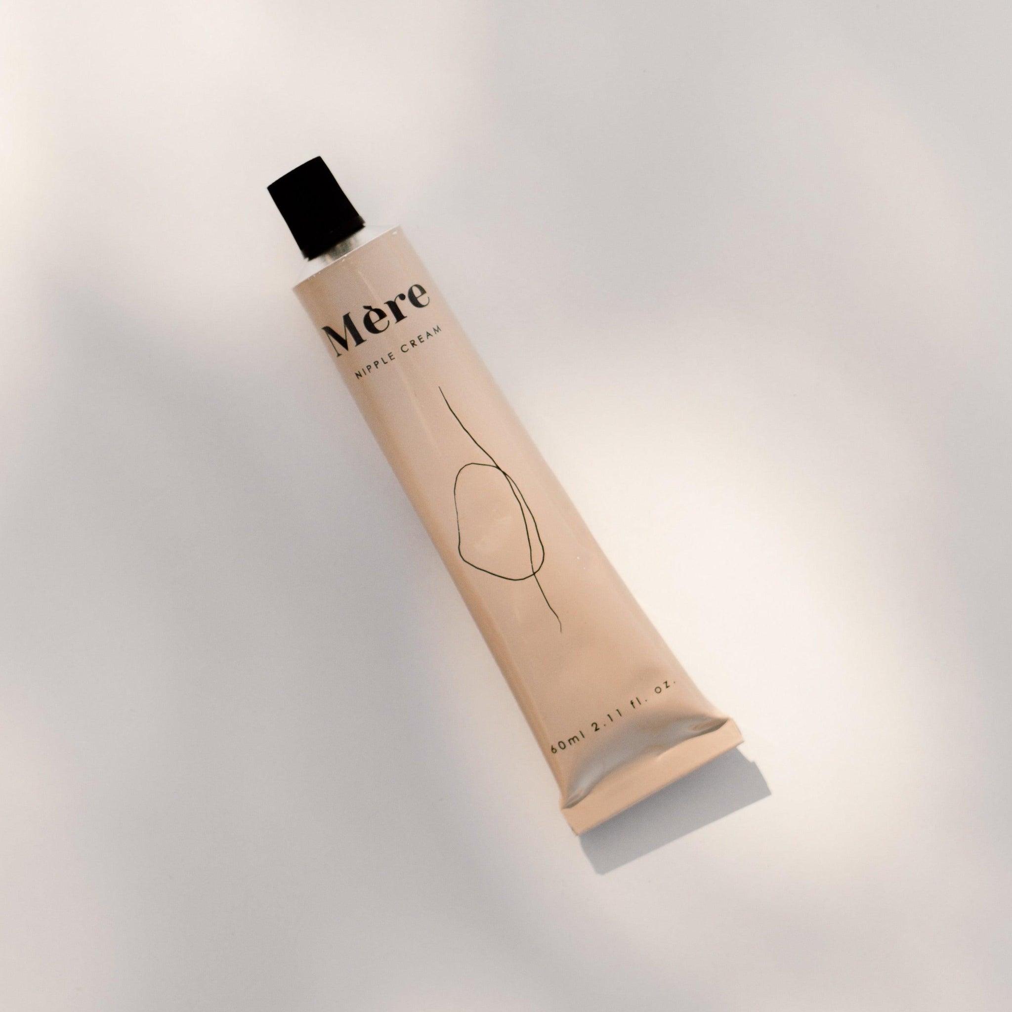 A tube of Mère nipple cream sitting on a white surface.