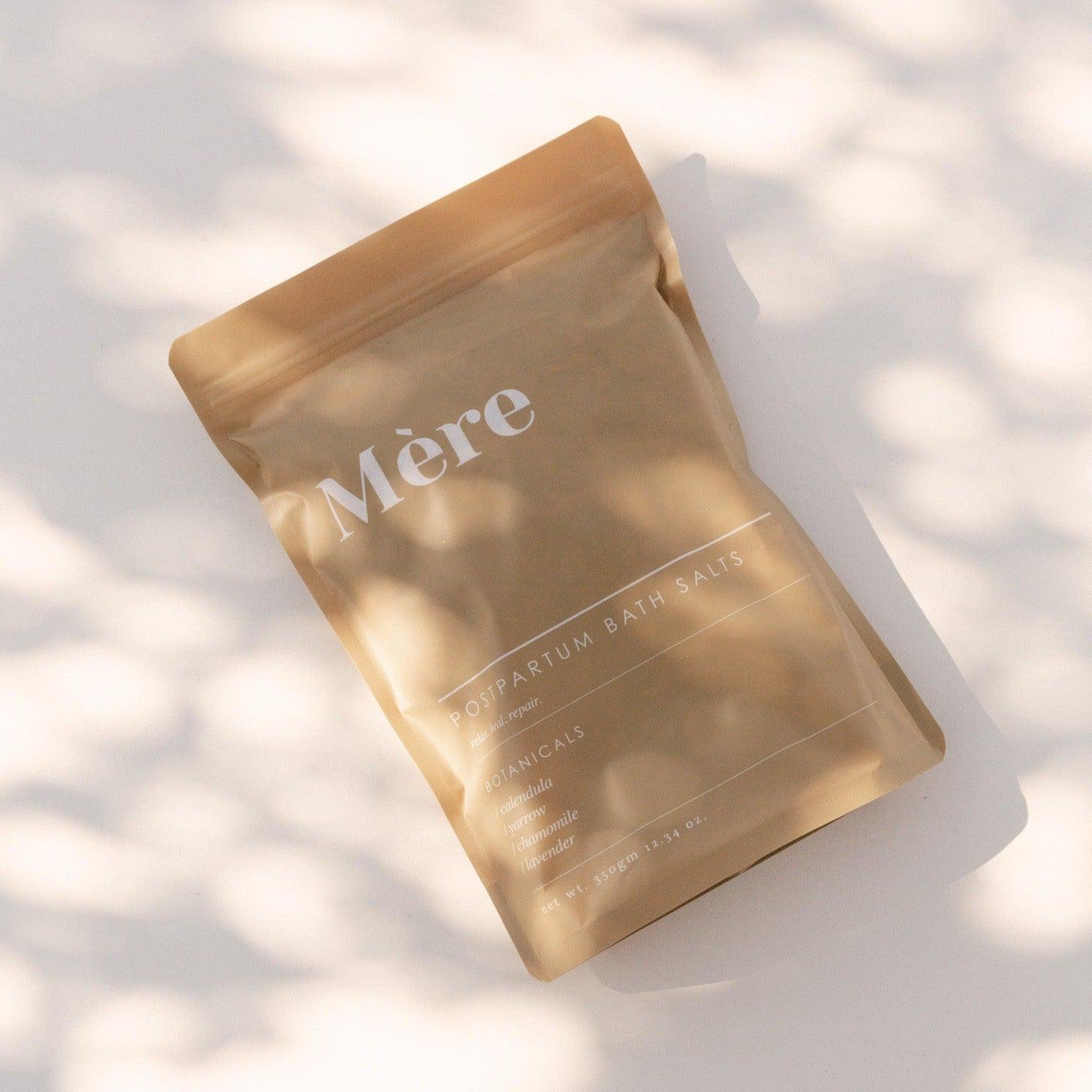 A bag with the word 'more' and Mère postpartum bath salts.