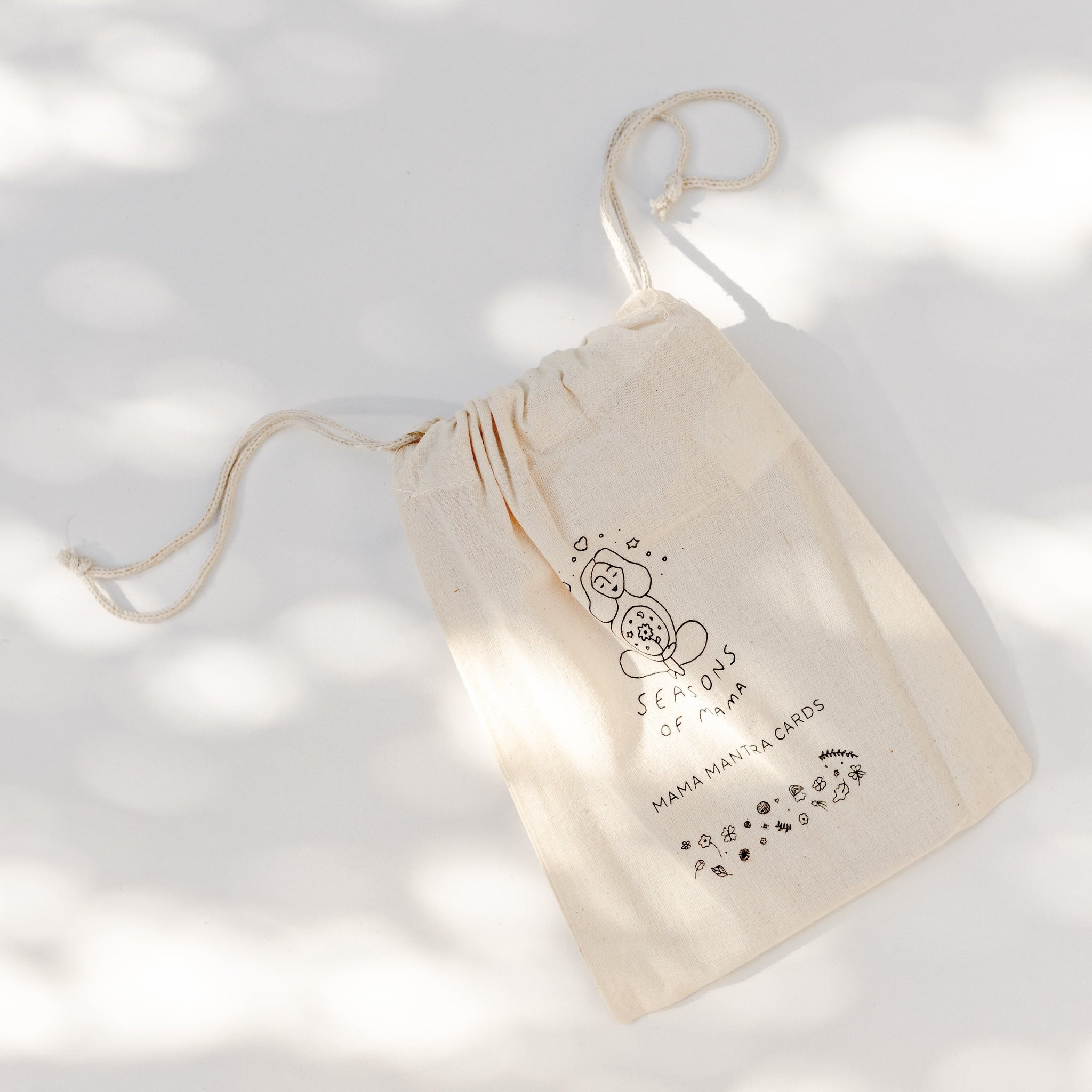 A branded calico bag featuring Mama Mantra Cards from the Seasons of Mama Mantra Card collection.