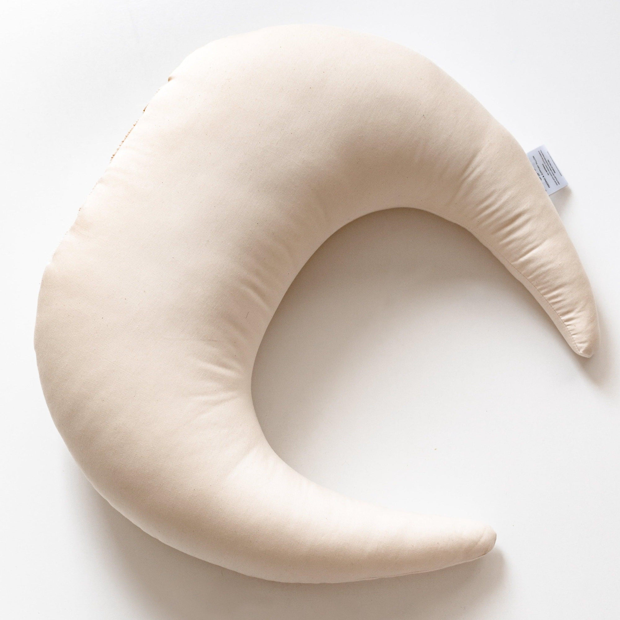 A crescent shaped Snuggle Me Feeding & Support Pillow | Natural on a white surface.