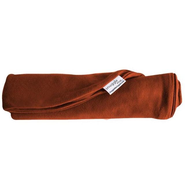 The Snuggle Me Lounger Cover in the shade Gingerbread rolled up on a white surface.