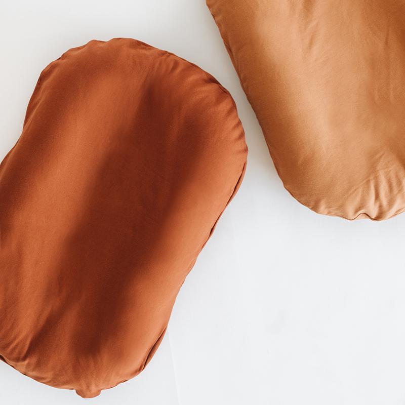 Two Snuggle Me Lounger Cover | Gingerbread pillows on a white surface.
