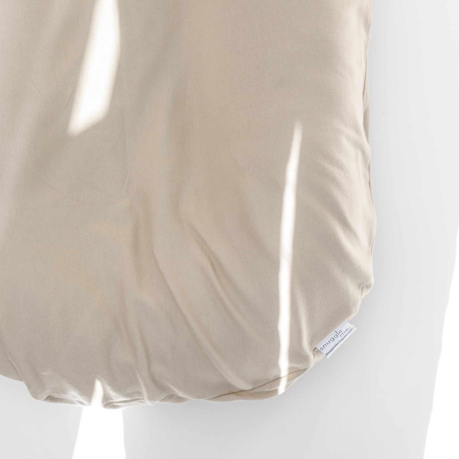 A close up image of The Snuggle Me® Lounger on a white surface.