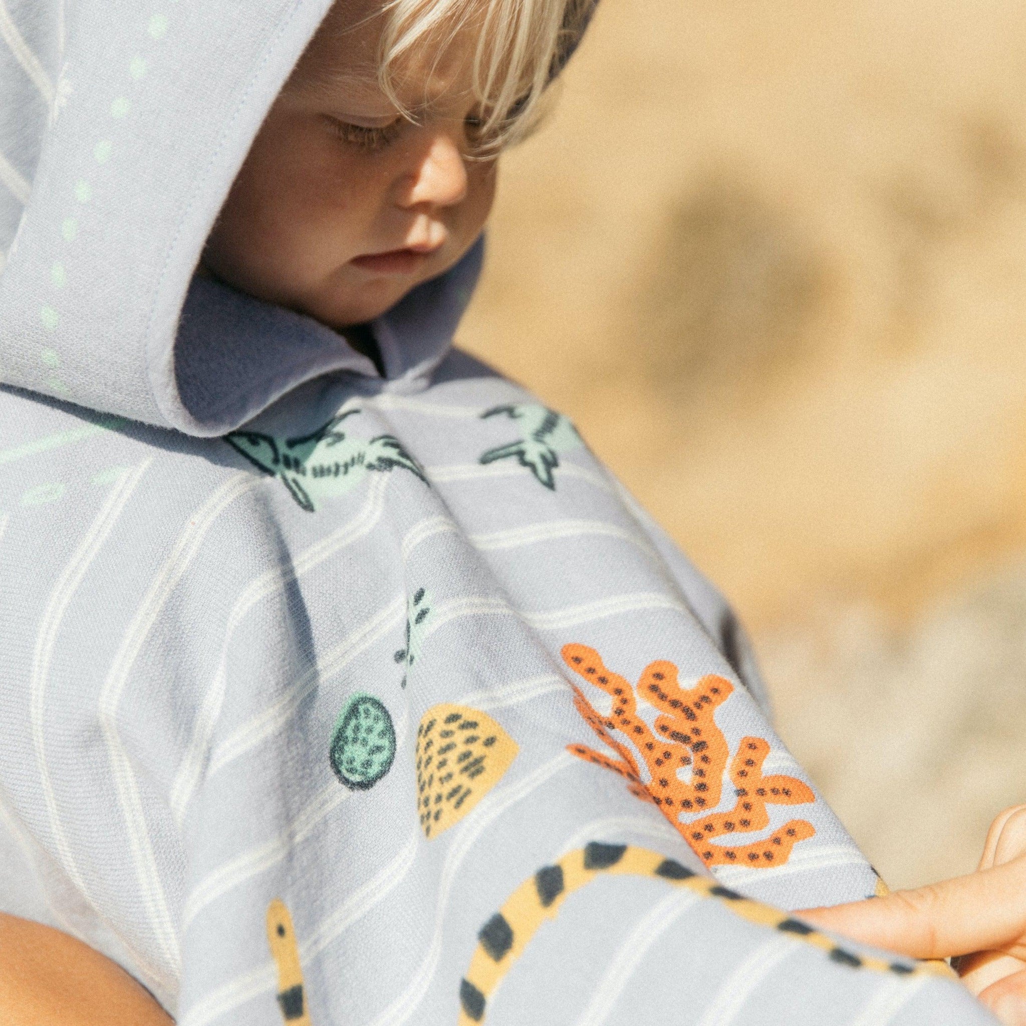 Made from 100% soft cotton, finished with a hood and the signature eyelash fringing, our Buccaneer Petite Poncho features hand illustrated sea creatures to keep your little one's imagination running wild.